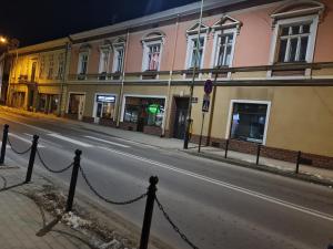 an empty city street at night with buildings at Noclegi w Sercu Miasta in Sanok