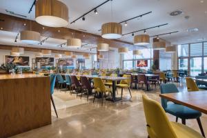 a restaurant with tables and chairs and windows at Hotel Nais Nis Autoput in Niš