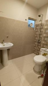 a bathroom with a toilet and a sink and a shower at Hotel 26 in Islamabad