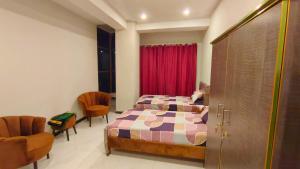 a bedroom with a bed and a red curtain at Hotel 26 in Islamabad