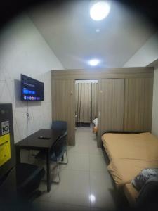 a bedroom with a bed and a desk and a tv at Staycation in Tropez 924 in Manila