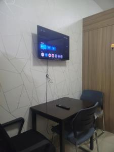 a table with chairs and a tv on a wall at Staycation in Tropez 924 in Manila