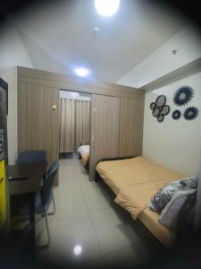 a bedroom with a large bed and a desk and a desk at Staycation in Tropez 924 in Manila +2 photos