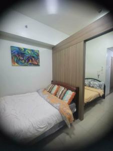 a bedroom with a bed and a painting on the wall at Staycation in Tropez 924 in Manila