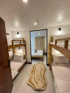a room with three bunk beds and a mirror at Camila Hostel Coron in Coron