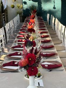 a long table with red napkins and flowers on it at Mon Resort by Ana1St in Scărişoara