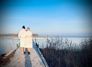 two people are standing on a wooden bridge over a body of water at Hotel Frederiksminde in Præstø +29 photos