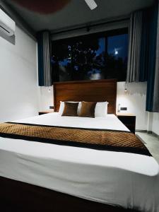 a bedroom with a large bed with a large window at BlueTide Hiriketiya in Hiriketiya