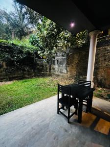 a black table sitting on a porch with a bench at BlueTide Hiriketiya in Hiriketiya