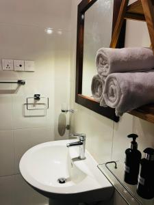 a bathroom with a sink and a mirror and towels at BlueTide Hiriketiya in Hiriketiya