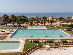 an overhead view of a pool with umbrellas and chairs at Triscinamare Hotel Residence in Triscina