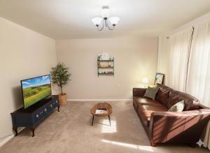 a living room with a couch and a flat screen tv at Stylish 3-Bed Maisonette - Sleeps 6 - Free Parking in Heswall
