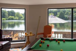 a living room with a pool table and a large window at Lakeside International Hotel in Camberley