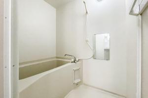a bath tub in a bathroom with a mirror at Osaka house honkan なんば-心斎橋エリア in Osaka