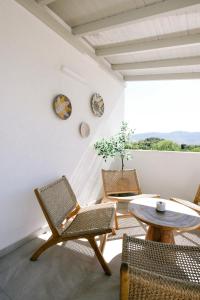 a room with chairs and a table and a table at Golden Gaia Villas in Kipía