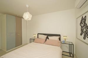 a bedroom with a bed with white sheets and pink pillows at Sunset on Sirmione in Sirmione