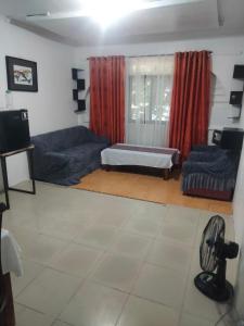 a living room with a couch and a bed at SEASCAPE in Moalboal
