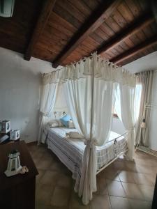 a bedroom with a canopy bed with white curtains at Aligia Chalet in Nebida