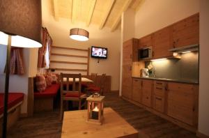 a living room with a kitchen and a dining room at Cesa Dolomia Apartments in Canazei