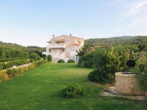a house with a large yard with green grass at Bella Villa in Vaia