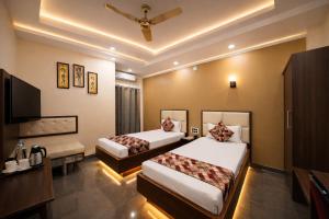 a hotel room with two beds and a television at Hotel New Rajasthan in Rānchī +10 photos