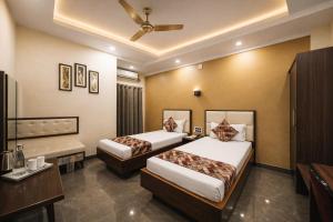 a hotel room with two beds and a desk at Hotel New Rajasthan in Rānchī
