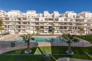 a large building with palm trees in front of it at Casa Rico in Guardamar del Segura