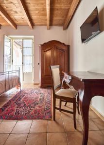 a room with a desk and a chair and a tv at Agriturismo Podere La Piazza in Costigliole dʼAsti