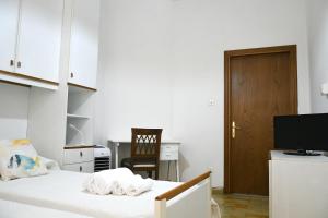 a bedroom with a bed with a desk and a television at Casa Cate in Poggibonsi
