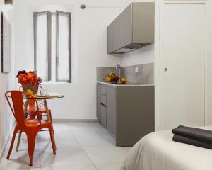 a kitchen with a table and a chair and a sink at 2D - Home 32 Apartments in Modena