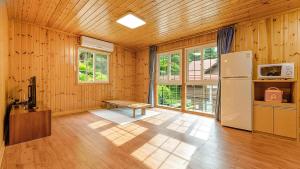 a kitchen with a refrigerator and a bench in a room at Gapyeong Humantown Pension in Gapyeong +8 photos