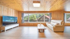 a living room with a couch and a flat screen tv at Gapyeong Humantown Pension in Gapyeong