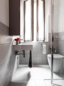 a white bathroom with a sink and a toilet at 2D - Home 32 Apartments in Modena +16 photos