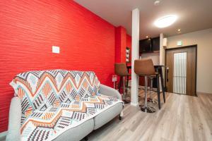 a living room with a couch and a red wall at 三十三Tsuki in Kyoto
