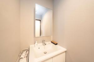 a white bathroom with a sink and a mirror at 三十三Tsuki in Kyoto +19 photos