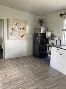 a kitchen with a black refrigerator and a table at Hideaway on Honikiwi in Otorohanga