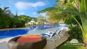 un complejo con piscina con sillas y una gran piscina en Aventuras Club en Puerto Aventuras