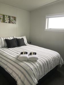 a bed with two pairs of towels on it at Hideaway on Honikiwi in Otorohanga