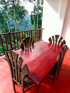 a wooden table and chairs on a balcony at Eco Diamond Palace in Ella