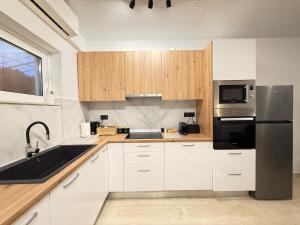 a kitchen with white cabinets and a stainless steel refrigerator at Dvillas one bedroom apartment in Svoronata