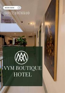 a sign for a ym boutique hotel on a wall at VYM Boutique Hotel in Balulang