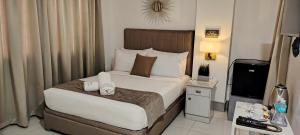 a hotel room with a bed and a television at VYM Boutique Hotel in Balulang