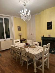 a dining room with a table with chairs and a chandelier at LA Combe in Confolens