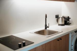 a kitchen counter with a sink and a stove at Olive 203 in Nafplio +3 photos