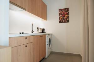 a kitchen with a sink and a washing machine at Olive 203 in Nafplio