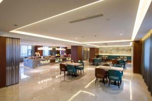 a restaurant with tables and chairs and a buffet at Orange Crystal Hotel Nanjing Museum in Nanjing