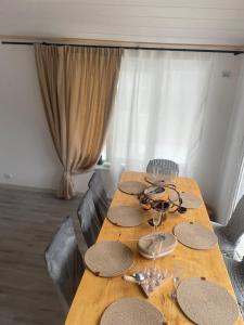 a wooden table with plates and wine glasses on it at Mini Хаус Ясіня in Yasinya +4 photos