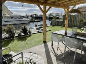 a patio with a table and chairs and a boat at Park De Markol Love Lemmer in Lemmer