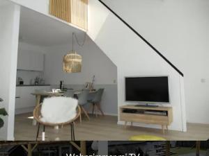 a living room with a tv and a table with a chair at Park De Markol Love Lemmer in Lemmer