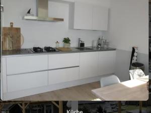 a white kitchen with white cabinets and a table at Park De Markol Love Lemmer in Lemmer +5 photos